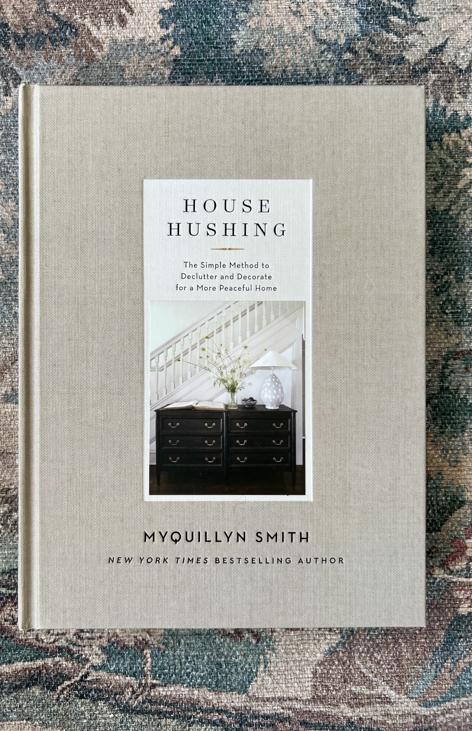 The cover of "House Hushing" sitting on floral tablecloth.