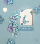 Cover image for NLT Thrive Creative Journaling Devotional Bible (Hardcover, Blue Flowers), isbn: 9781414368139