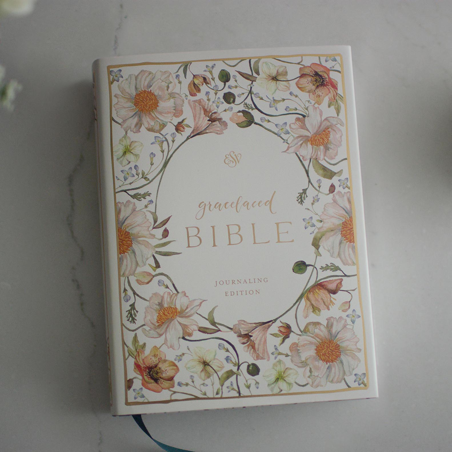 The cover of the Gracelaced Bible, Journaling Edition (hardcover). Pink, yellow, and green flowers surround the title of the Bible in a golden script.