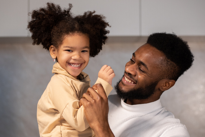 Picture of a smiling father holding his little girl.