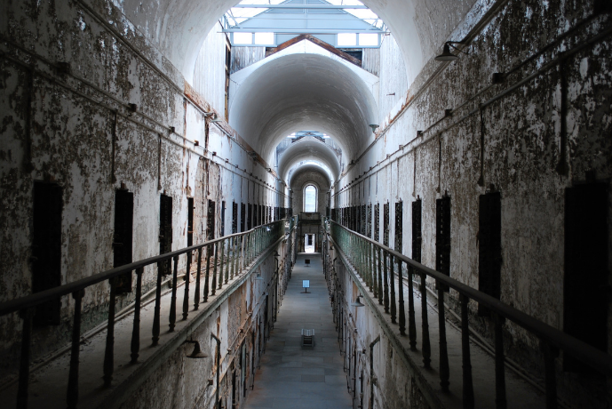 A long, decrepit hallway in an asylum stretching away.
